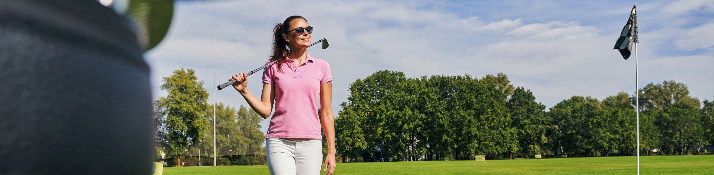 Woman on the golf course wearing pink polo shirt