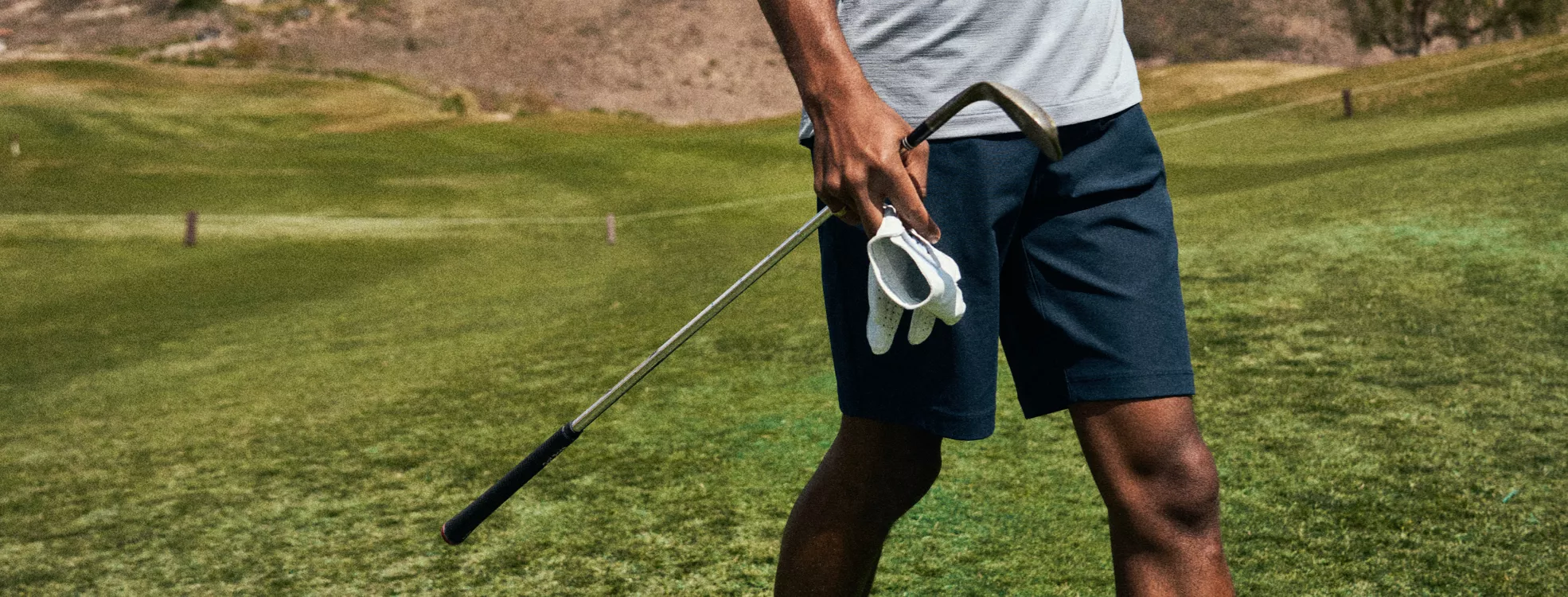 Golfer with shorts walking the course.